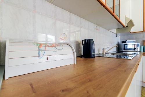 a kitchen with a wooden counter top with a microwave at Holiday apartment Kali - Ugljan island in Kali