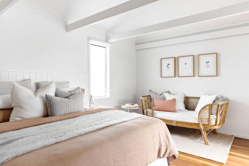 a bedroom with a bed and a couch at Cape Beach House in Byron Bay