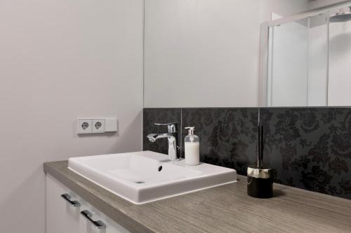 y baño con lavabo blanco y espejo. en Apartament 208, en Międzyzdroje