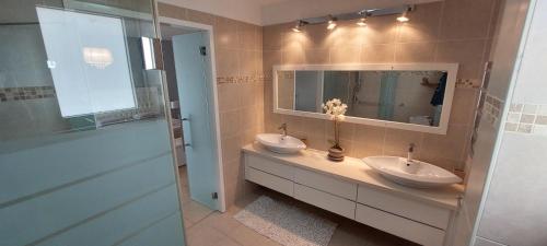 a bathroom with two sinks and a mirror at Amazing sea view Penthouse close to beach in Ashdod