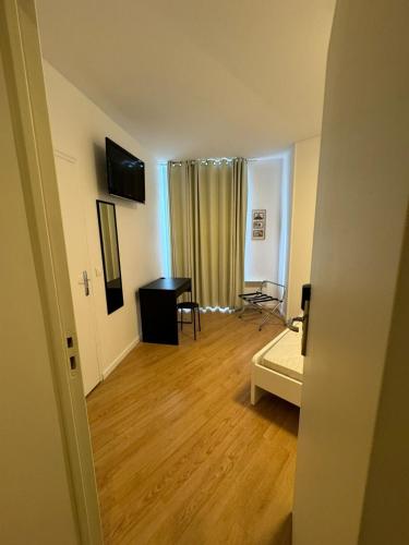 Cette chambre comprend un bureau et une table. dans l'établissement ETOILES DE MANTES, à Mantes-la-Jolie