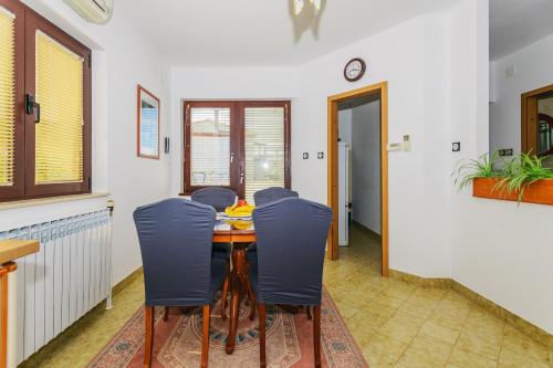 a dining room with a table and blue chairs at Holiday apartment Kali - Ugljan island in Kali