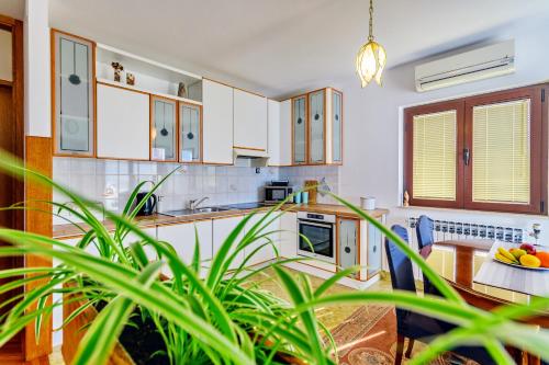 a kitchen with white cabinets and a table at Holiday apartment Kali - Ugljan island in Kali