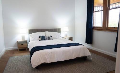a bedroom with a large bed and two windows at East Albury home near hospital & sports precinct in Albury