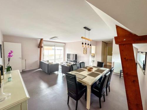 une salle à manger et un salon avec une table et des chaises dans l'établissement Appartement terrasse, à Saint-Jean-de-Daye
