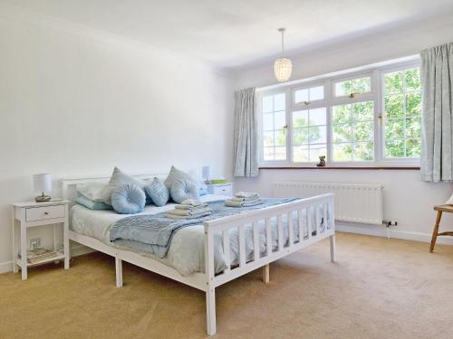 a white bedroom with a bed with blue pillows at Valetta Park in Emsworth