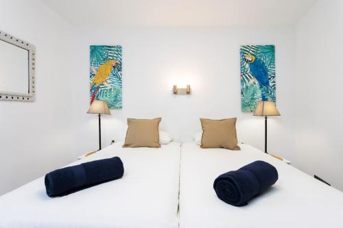 two beds in a white room with two lamps at OkStay Apt Bencomo 50 m from the beach in Puerto de la Cruz
