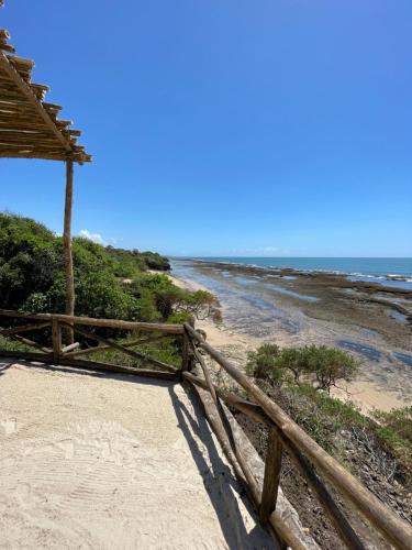a wooden fence on a beach with the ocean at Pangani Cliffs Lodge in Pangani