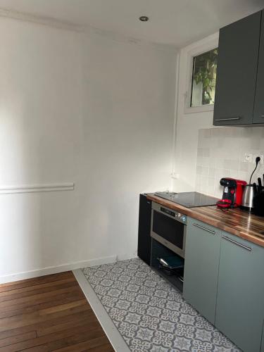 une cuisine avec une cuisinière et un comptoir dans l'établissement Cosy appartement in Paris, à Paris