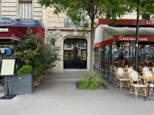 grupa stołów i krzeseł poza restauracją w obiekcie Cosy appartement in Paris w Paryżu