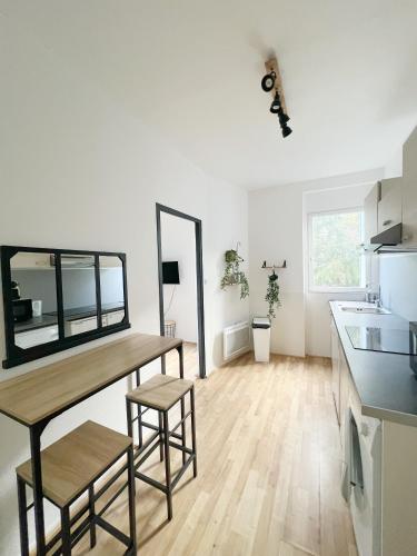 une cuisine avec une table et des tabourets dans une pièce dans l'établissement L'industriel de Kléber - Gare - Netflix - Calme, à Toulouse