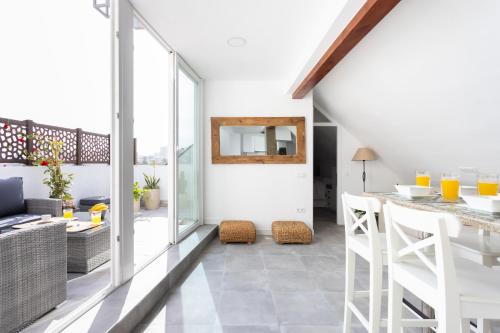 a kitchen and living room with a table and chairs at OkStay Penthouse Bencomo with beach views in Puerto de la Cruz