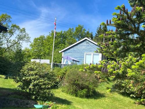 Una casa blu con una bandiera americana nel cortile di 4 Person Holiday Home Sletta 