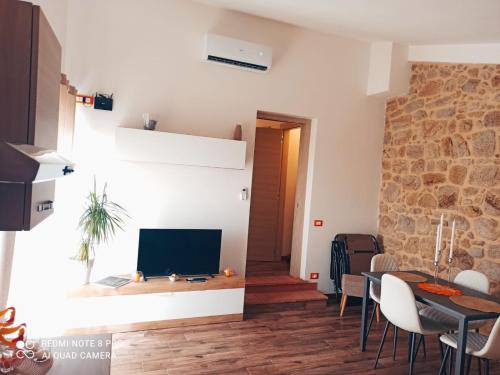 a living room with a tv and a table with chairs at Casa Fonte in Roccastrada