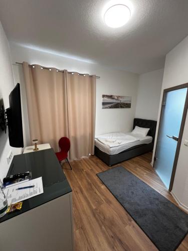 a small room with a bed and a desk at Sleep & Go Motel in Unterbalbach