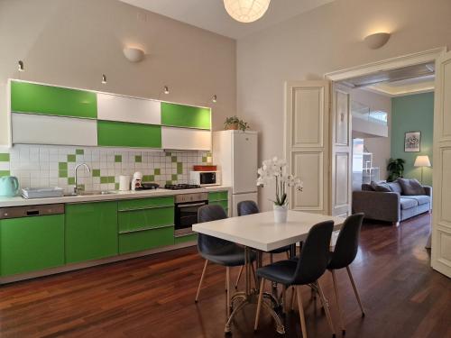 a kitchen with green cabinets and a table and chairs at Apartment Exclusive View Cvjetni trg in Zagreb