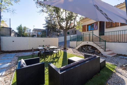 a patio with a table and an umbrella at Cozy house in Priorat! Barbecue & Relax - Climbing & Views in Poboleda