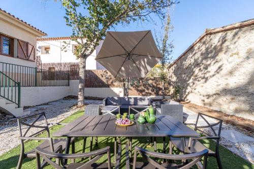 a table and chairs with an umbrella on a patio at Cozy house in Priorat! Barbecue & Relax - Climbing & Views in Poboleda