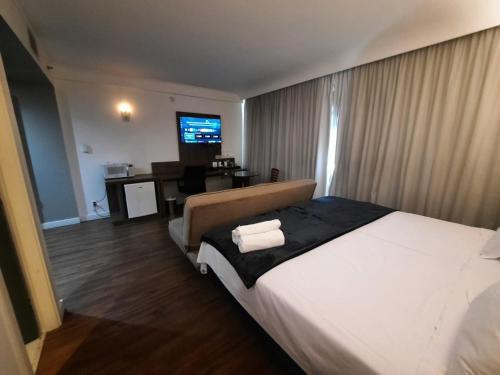 una camera d'albergo con un grande letto e una scrivania di Flat Hotel Internacional Ibirapuera 2534 a San Paolo