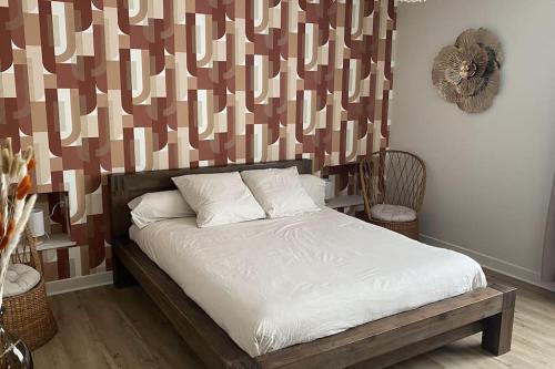 a bed with white sheets and pillows in a bedroom at Le cocon du Faubourg in Vendôme