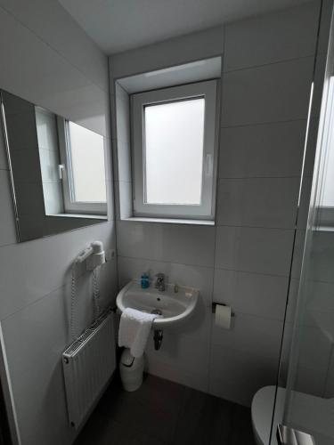 a bathroom with a sink and a mirror at Sleep & Go Motel in Unterbalbach