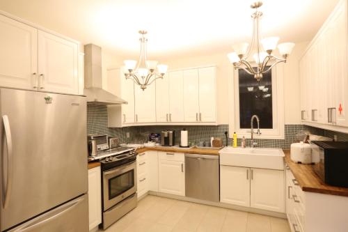 a kitchen with white cabinets and stainless steel appliances at Xiao Wang in Toronto