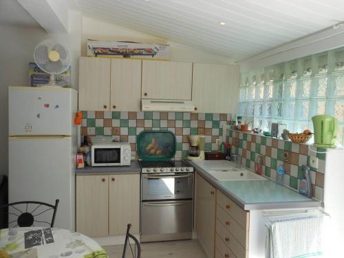 Il comprend une cuisine équipée d'un réfrigérateur et d'une cuisinière. four supérieur dans l'établissement VILLA 3 PCES MEZ 52m2 + TERRASSE 16m² REF 4058, à Le Castellas