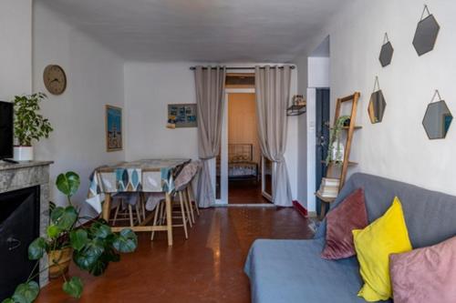 ein Wohnzimmer mit einem blauen Sofa und einem Tisch in der Unterkunft Le cosy in Marseille