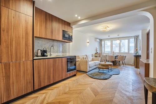 une cuisine avec des placards en bois et un salon dans l'établissement Résidence Centre de Paris by Studioprestige, à Paris