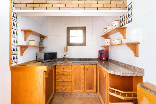 a kitchen with wooden cabinets and a counter top at OkStay Casa de campo La Hoya Tenerife in Güimar