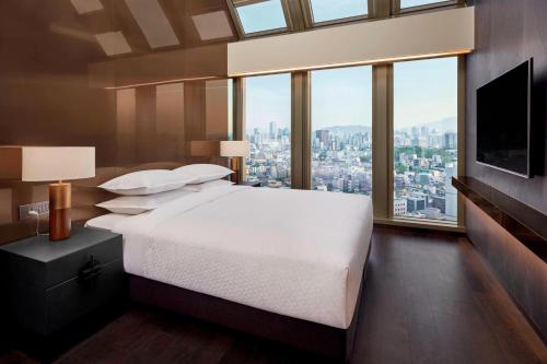 - une chambre avec un grand lit et une grande fenêtre dans l'établissement Four Points by Sheraton Seoul Gangnam, à Séoul