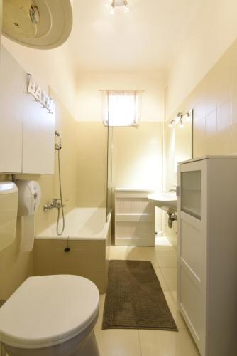 ニーレジハーザにあるMilán Apartmentの白いバスルーム(トイレ、シンク付)