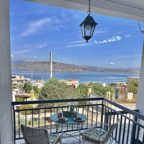 balcón con mesa, sillas y vistas al agua en Socratous House, en Salamina