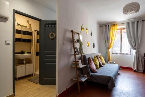 een woonkamer met een blauwe bank en een wastafel bij Le cosy in Marseille