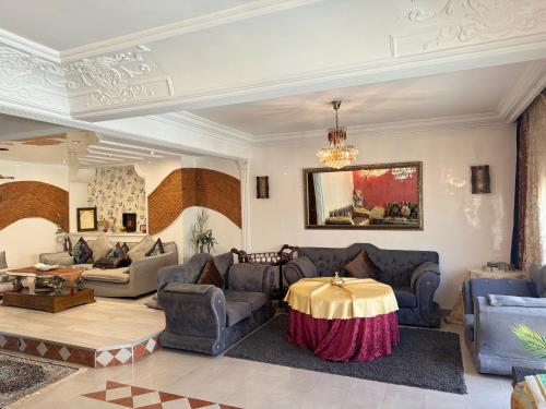 a living room with couches and a table at Luxury duplex in the centre of Maarif in Casablanca