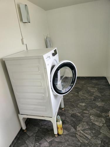 a washing machine with its door open in a room at Stuga på landet in Asarum