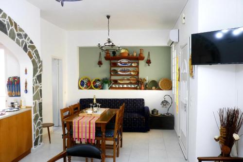 a dining room with a table and a couch at Arco In Pietra in Apolakkiá
