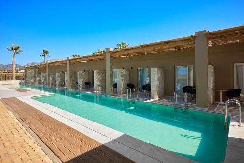 uma grande piscina num edifício com palmeiras em Malia Bay Beach Hotel & Bungalows em Malia