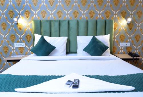 a bedroom with a white bed with a green headboard at Nidra Hotel in New Delhi