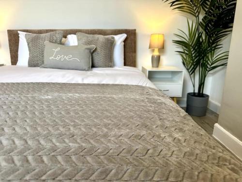 a bedroom with a bed with a pillow with the word love on it at 2 Bedroom City Centre House - Pet Friendly - Free Parking in Cardiff