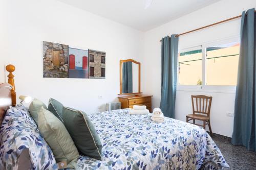 a bedroom with a bed with a blue comforter at OkStay Casa Maye Tenerife with jacuzzi and large outdoor area in Güimar