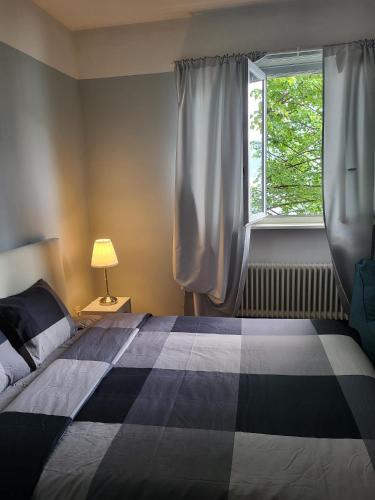 a bedroom with a black and white bed and a window at Dreamapartment 4 Roomlake in Lugano