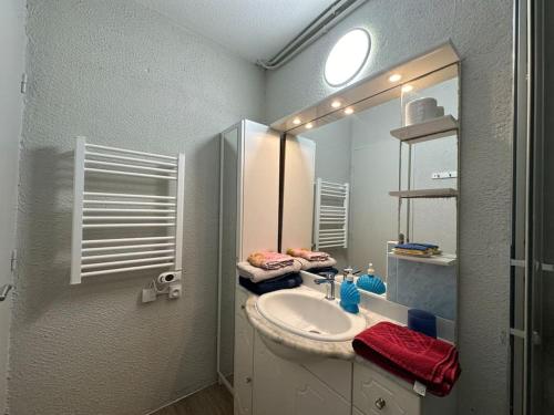 une salle de bain avec un lavabo et un miroir dans l'établissement Fonctionnel - 2 chambres - bien situé à 300m de la Plage - Parking Privé de Juin à Sept, à Canet