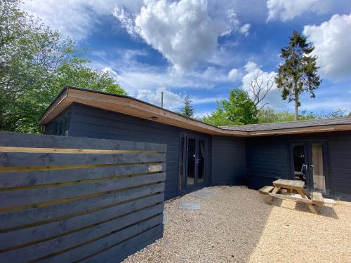 a blue building with a picnic table in front of it at Hunters Hideaway-Hot Tub-Wiltshire-Groups in Warminster