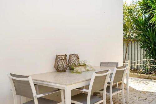 a white table and chairs with vases on it at Secret Garden Chalet No. 1 in San Pietro in Bevagna