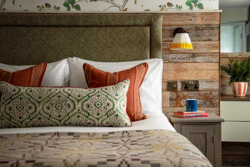 een slaapkamer met een bed met een houten hoofdeinde en kussens bij The Golden Lion at Settle in Settle