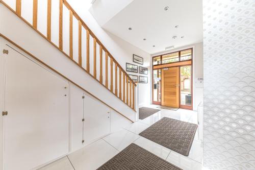 una escalera en una casa con paredes blancas y suelo blanco en Abbey Apartments Modern ApartHotel for Tourists & Professionals en Barrow in Furness