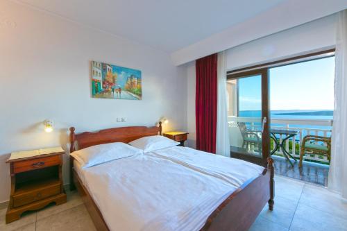 a bedroom with a bed and a view of the ocean at Adria Brela Apartments in Brela