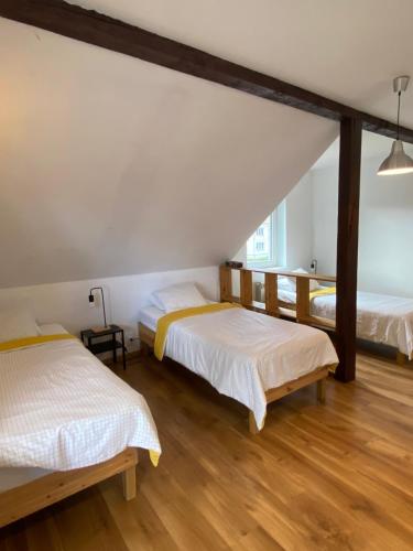 two beds in a room with wooden floors at Komfortowy Dom Bilard, Piłkarzyki, Gry Arcade in Goniadz