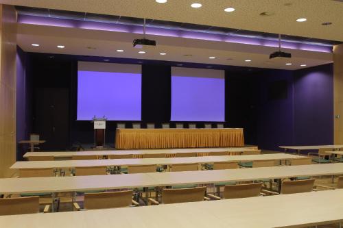 a lecture hall with tables and chairs with blue screens at Hotel DAP in Prague